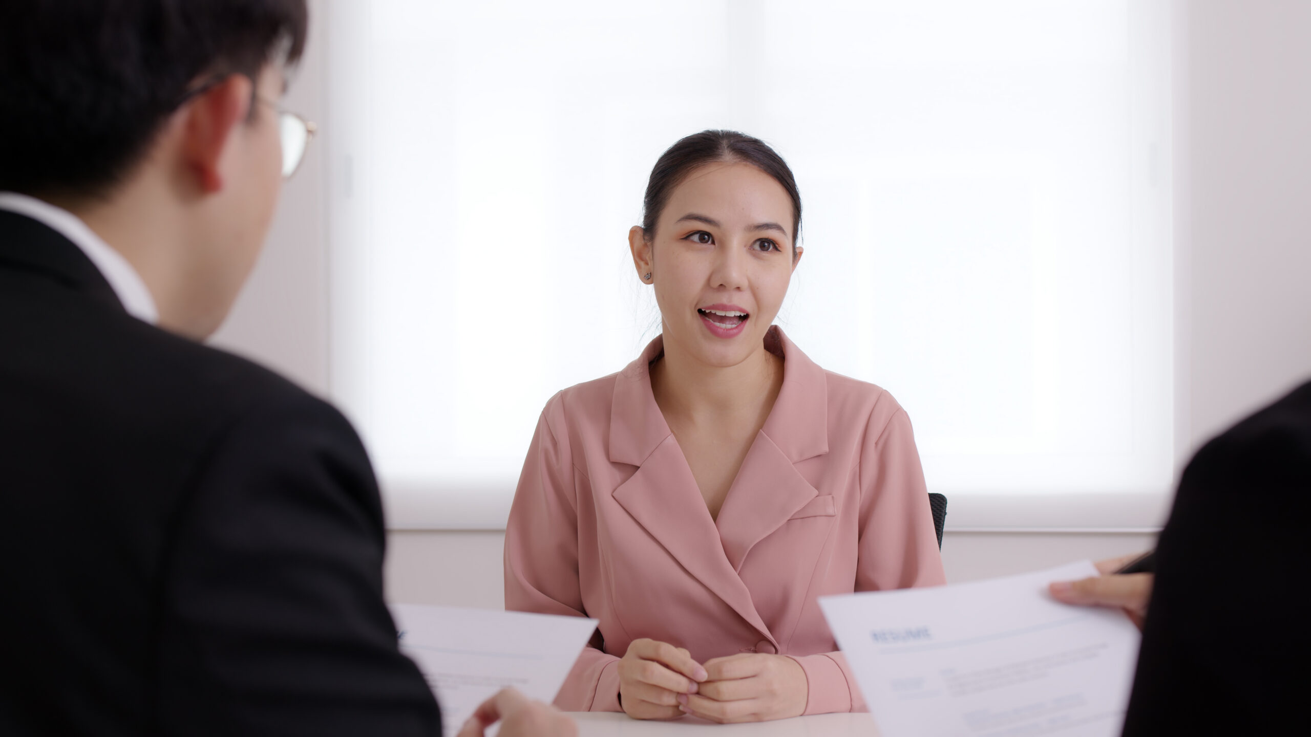 A female applicant talking to the recruiters in a marketing job interview.